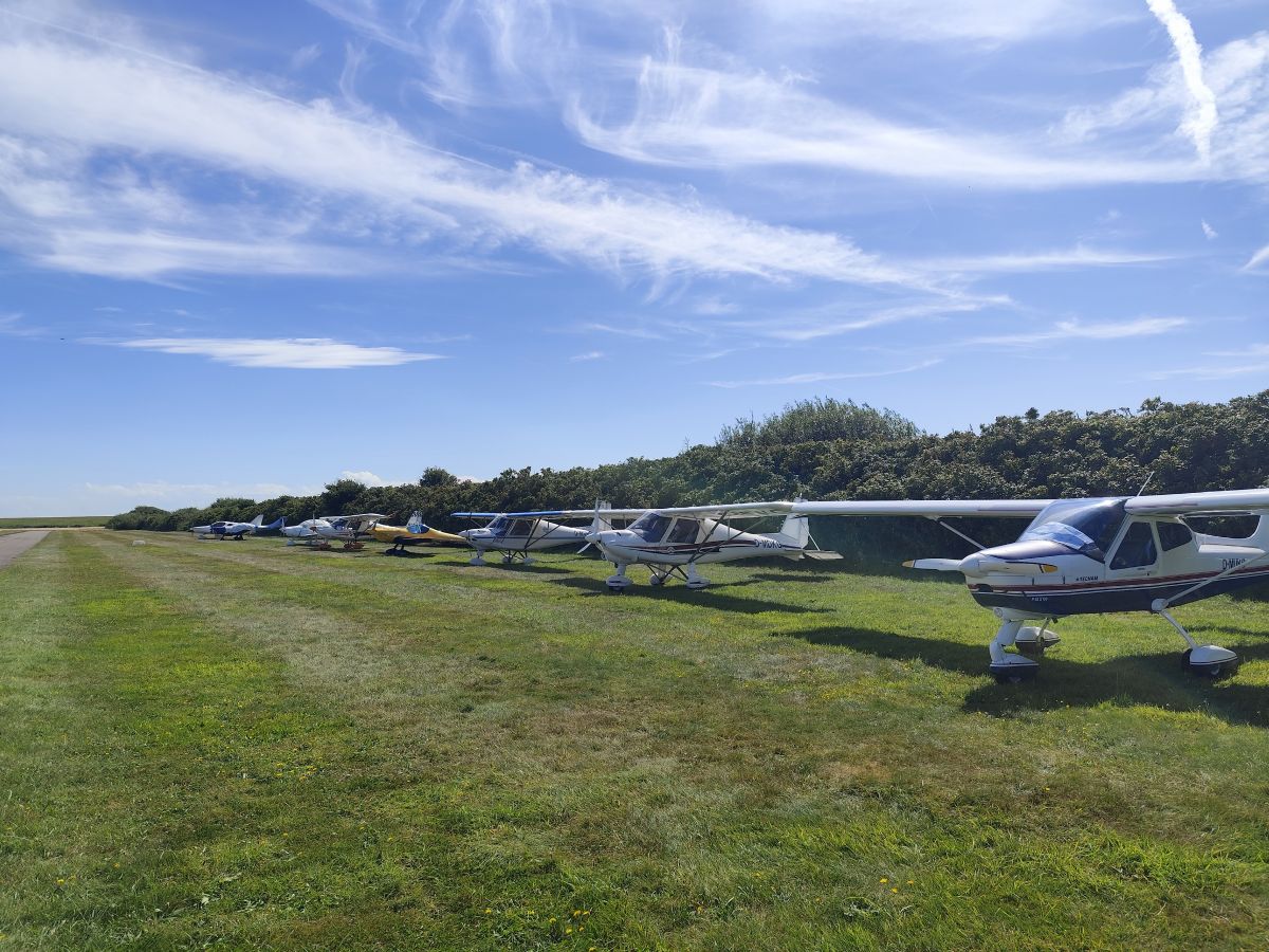 Das Bild zeigt viele Kleinflugzeuge aufgereiht auf dem Abstellplatz am Flugplatz Wangerooge